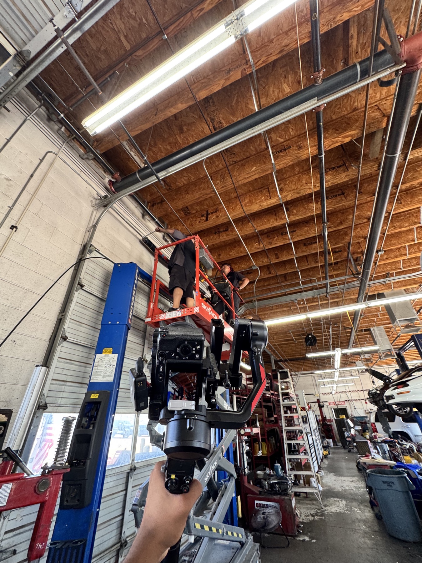 A handheld camera rig documenting a garage door client at work