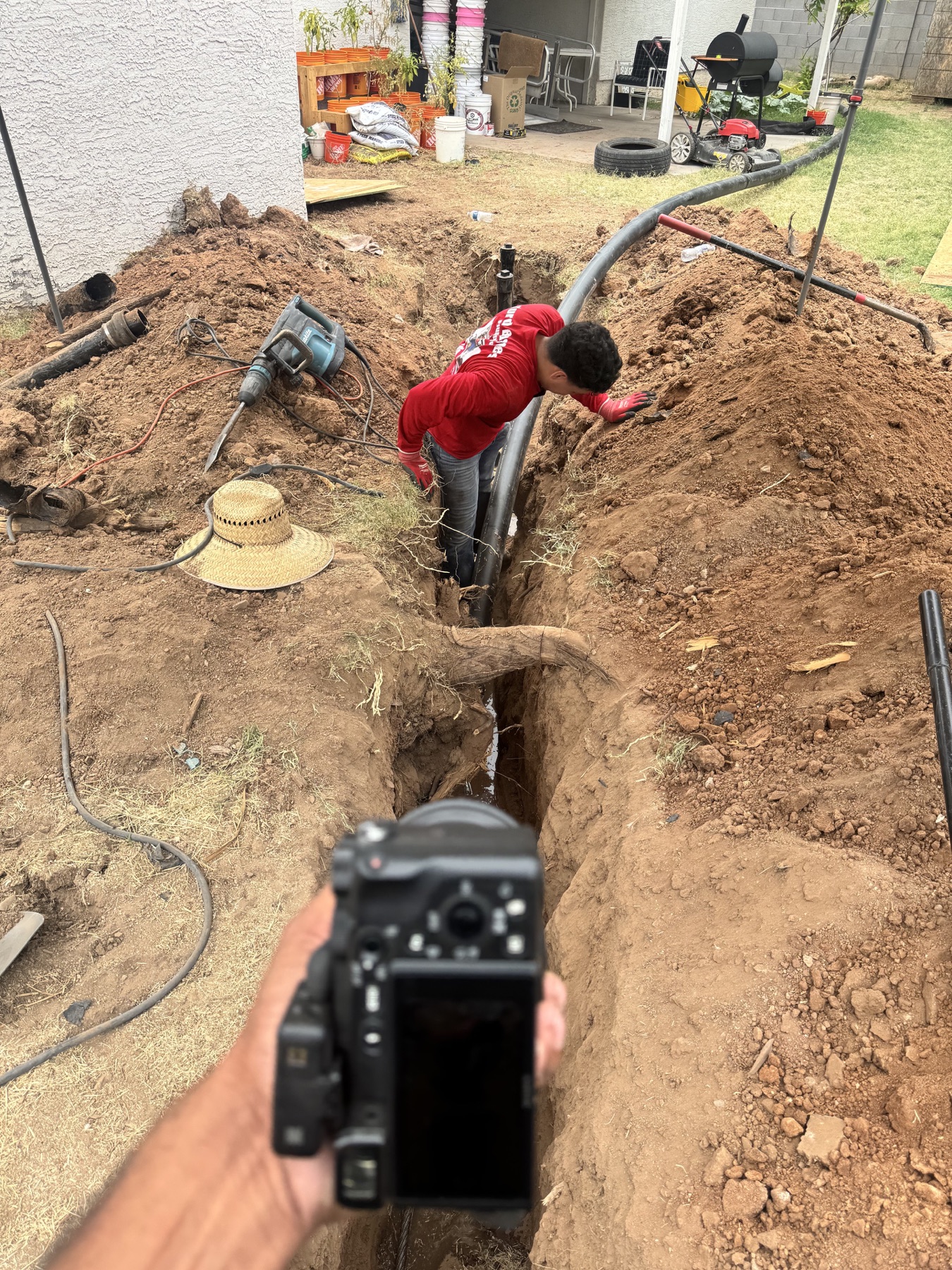 A Stray camera documenting a plumber working inside a residential trench