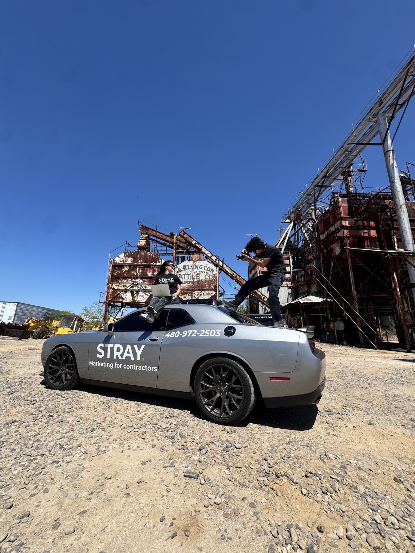 The Stray field crew producing content around their branded car at an industrial site in Arizona